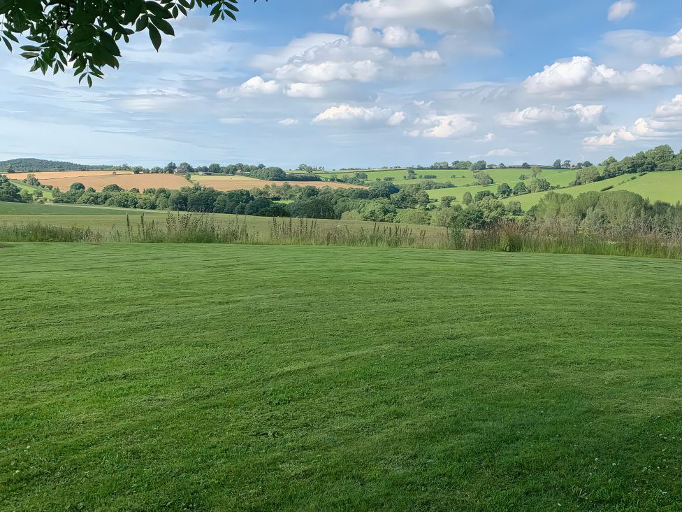 A view of rolling hills and fields with a lawn at Upper Home Farm