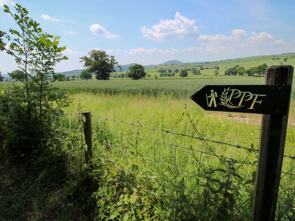 A field with a signpost directing to a walking path at Upper Home Farm near Cardington