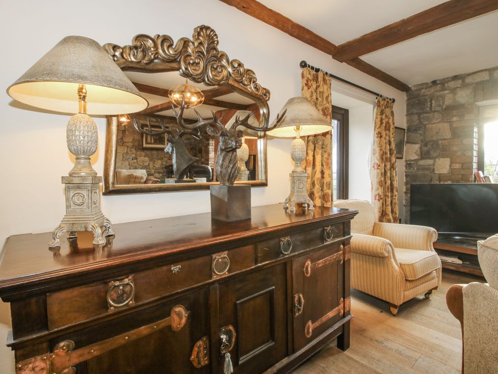 A living room with a sideboard and a lamp at Upper Home Farm near Cardington
