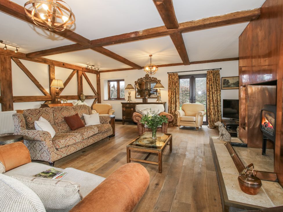 A living room with a sofa and fireplace at Upper Home Farm near Cardington