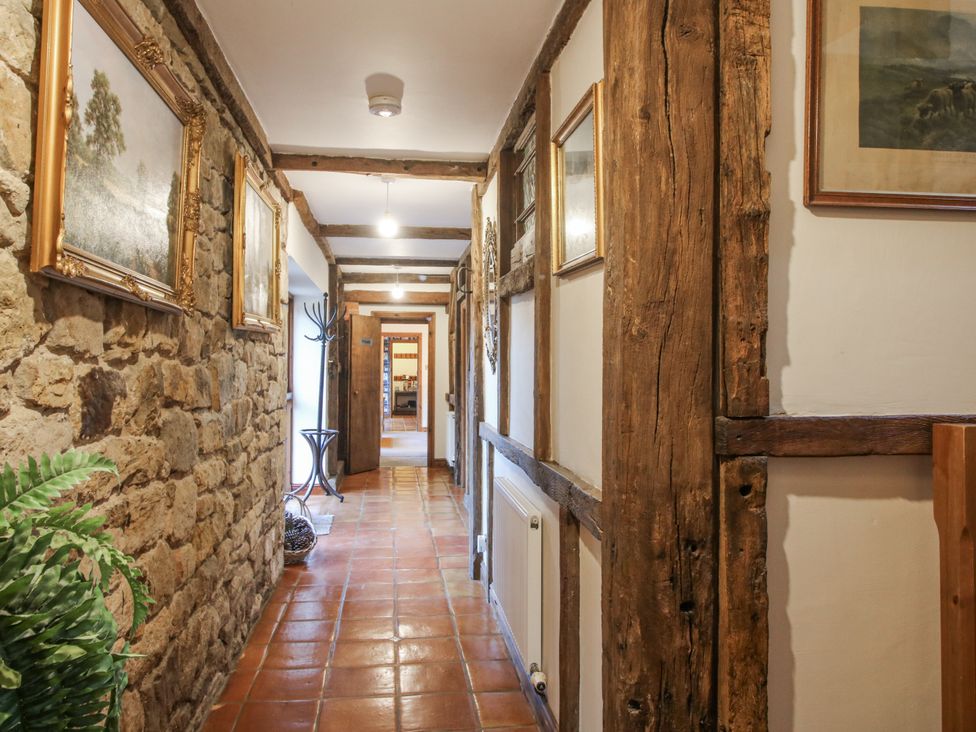 A hallway with stone walls and paintings at Upper Home Farm near Cardington