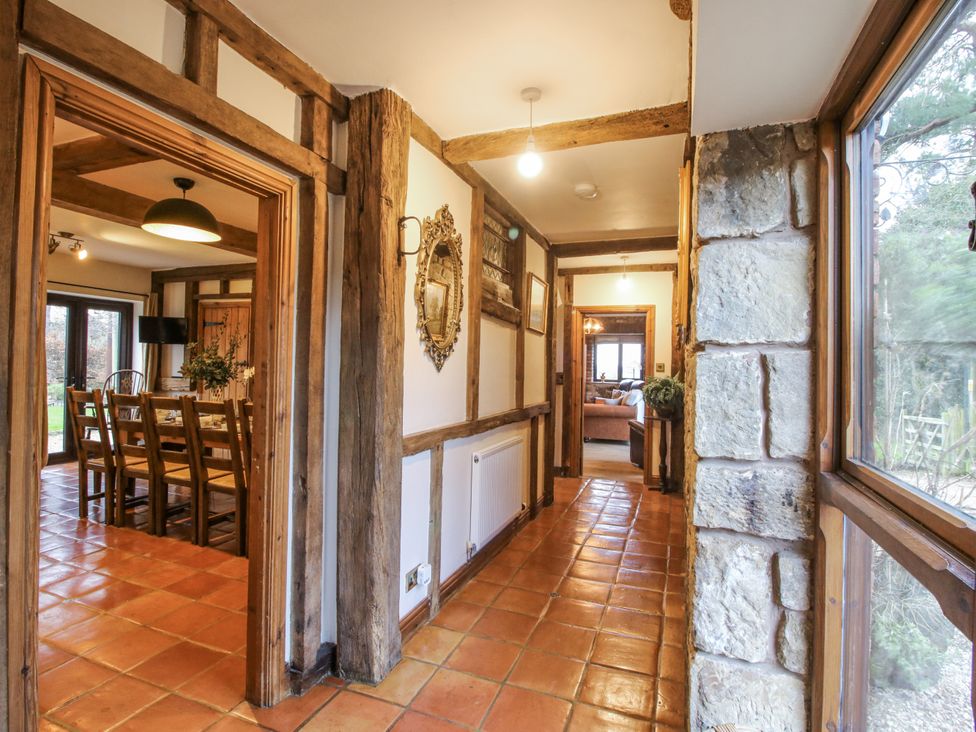 A hallway with wooden beams and a view to the dining area at Upper Home Farm near Cardington