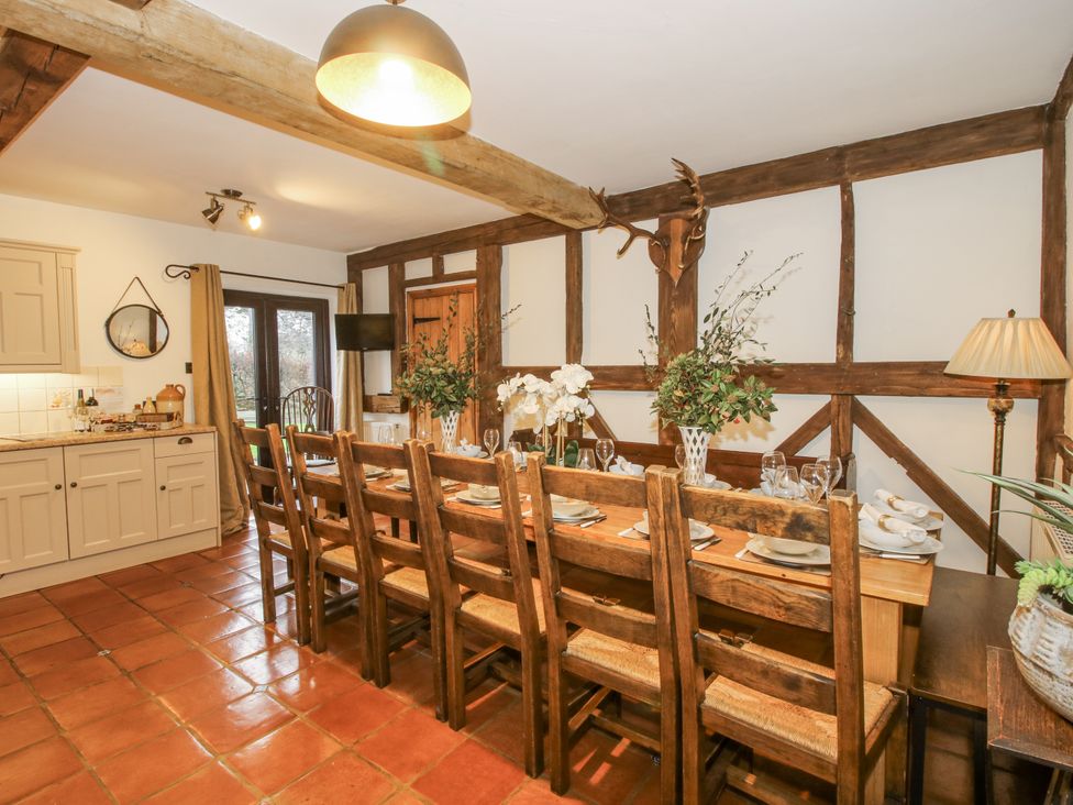 A dining room with a long table and wooden chairs at Upper Home Farm near Cardington