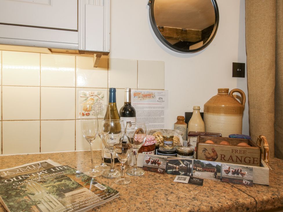 A kitchen counter with wine bottles, glasses, and preserves at Upper Home Farm near Cardington