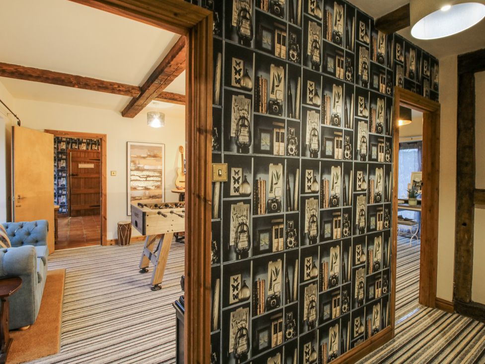 A hallway with a striped carpet and a foosball table at Upper Home Farm near Cardington