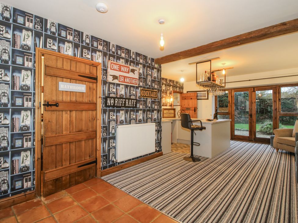 A bar area with stools and signs at Upper Home Farm near Cardington