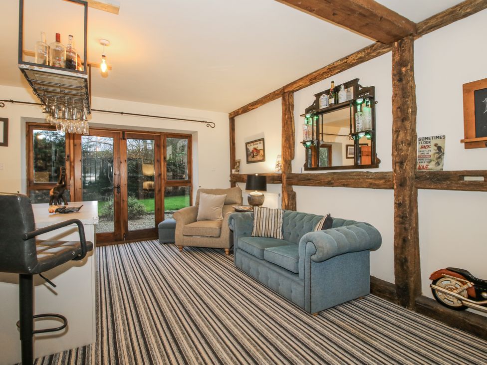 A living room with a sofa and armchair at Upper Home Farm near Cardington
