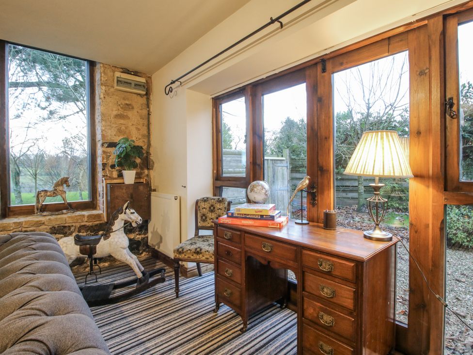A snug with a desk and sofa at Upper Home Farm near Cardington
