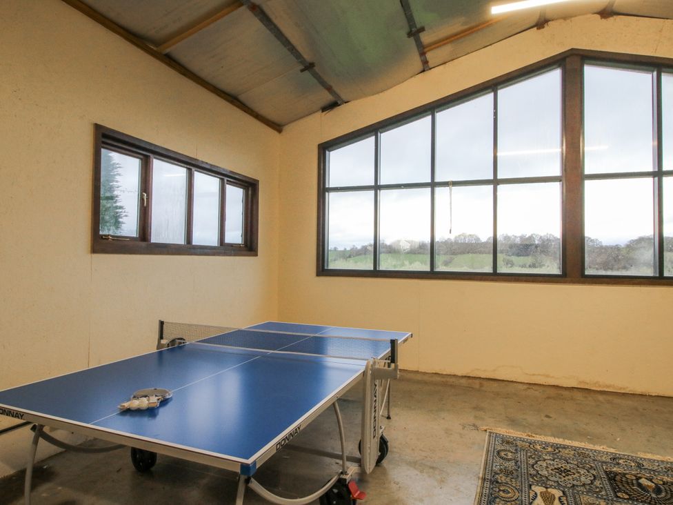 A games room with a table tennis table and large windows at Upper Home Farm near Cardington