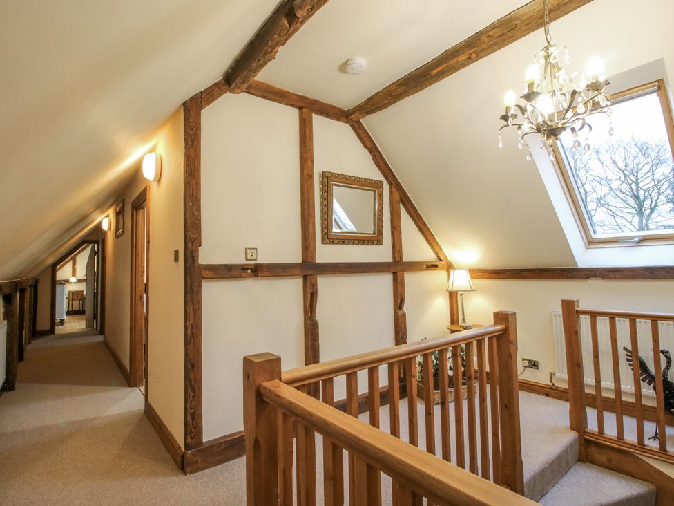 A hallway with a staircase and window at Upper Home Farm near Cardington