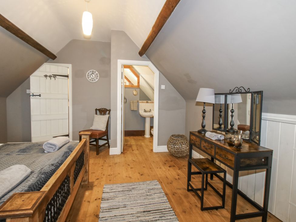 A bedroom with a bed and dressing table at Upper Home Farm near Cardington