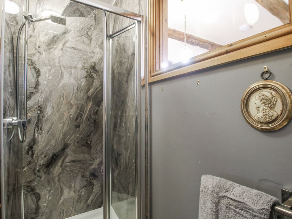 A shower with glass door and grey walls at Upper Home Farm near Cardington