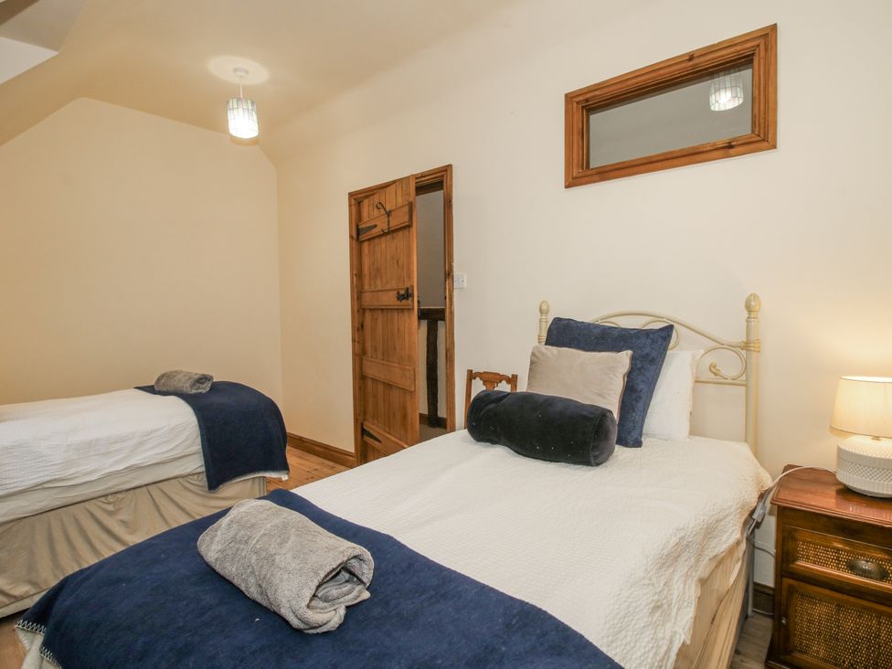 A bedroom with two beds and a nightstand at Upper Home Farm near Cardington