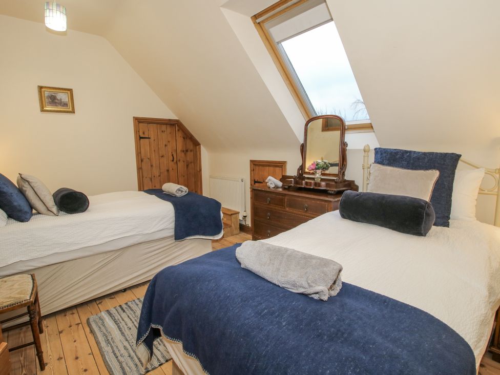 A bedroom with two beds and a dresser at Upper Home Farm near Cardington