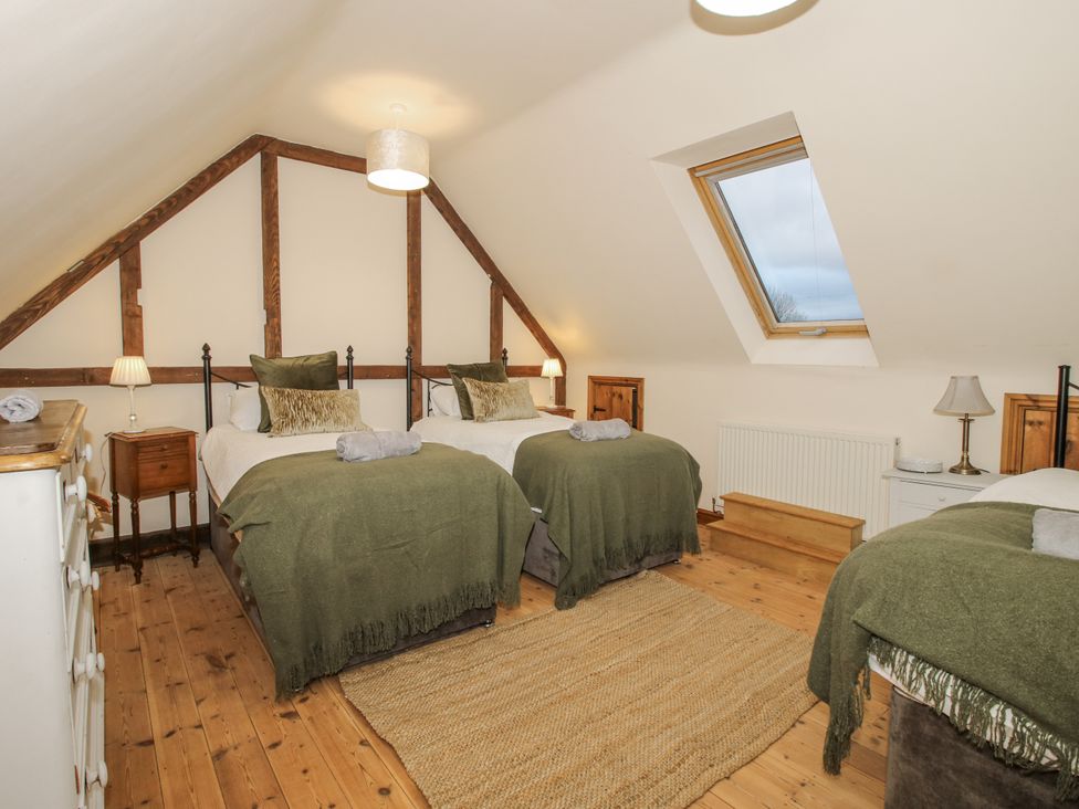 A bedroom with two beds and a skylight at Upper Home Farm near Cardington