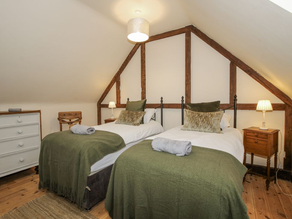A bedroom with twin beds and a dresser at Upper Home Farm near Cardington