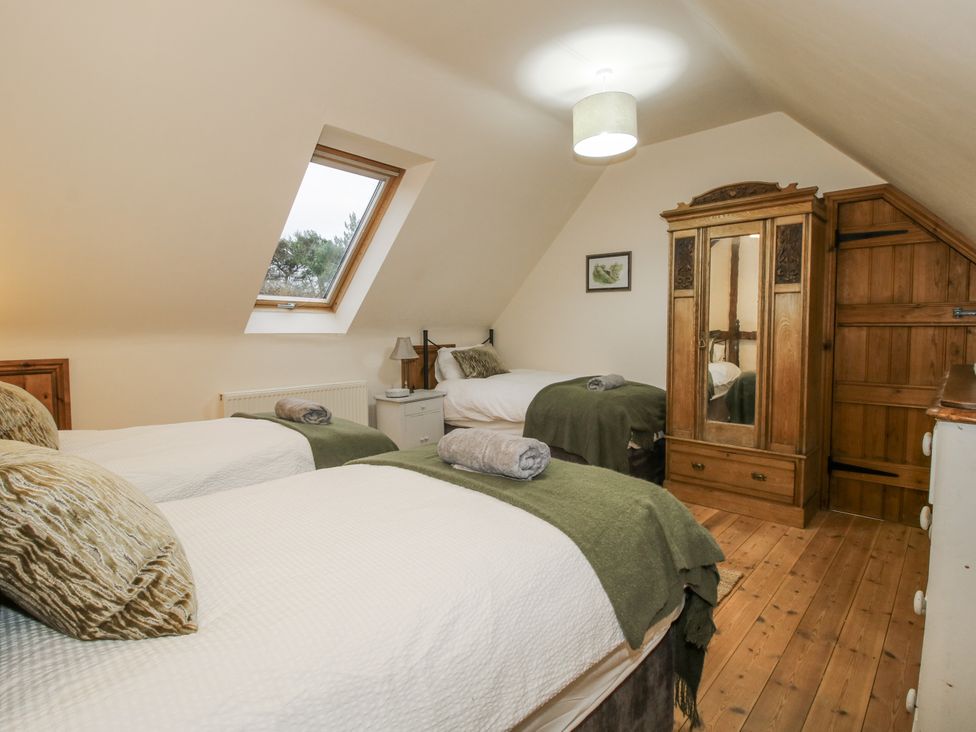 A bedroom with two beds and a wardrobe at Upper Home Farm near Cardington