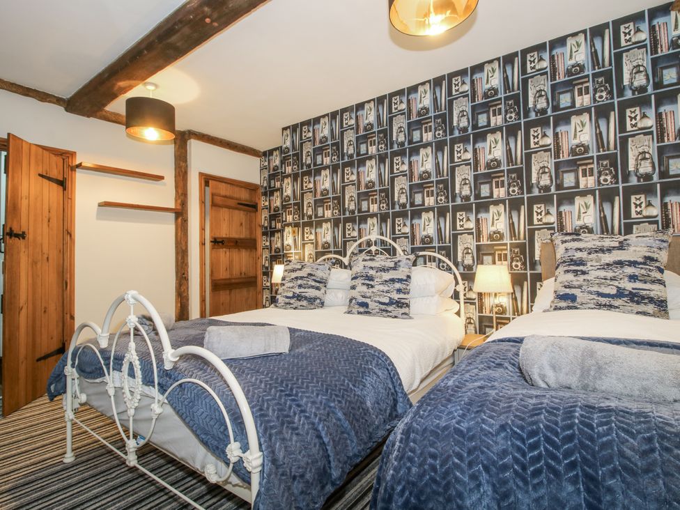 A bedroom with two beds and a decorative wall at Upper Home Farm near Cardington