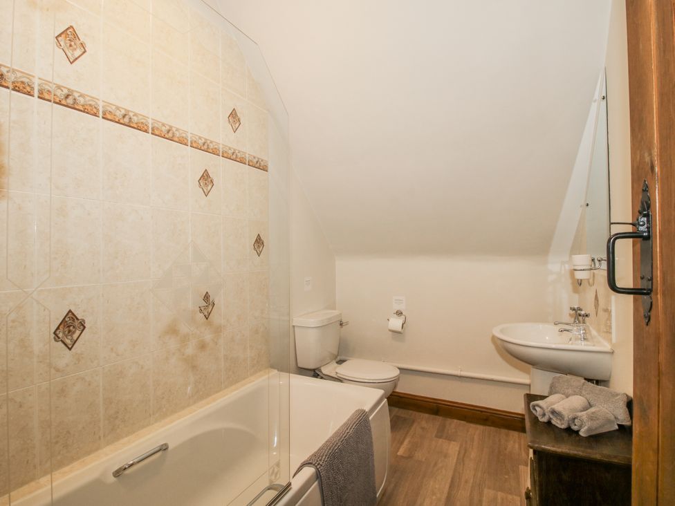 A bathroom with a bathtub, toilet, and sink at Upper Home Farm near Cardington