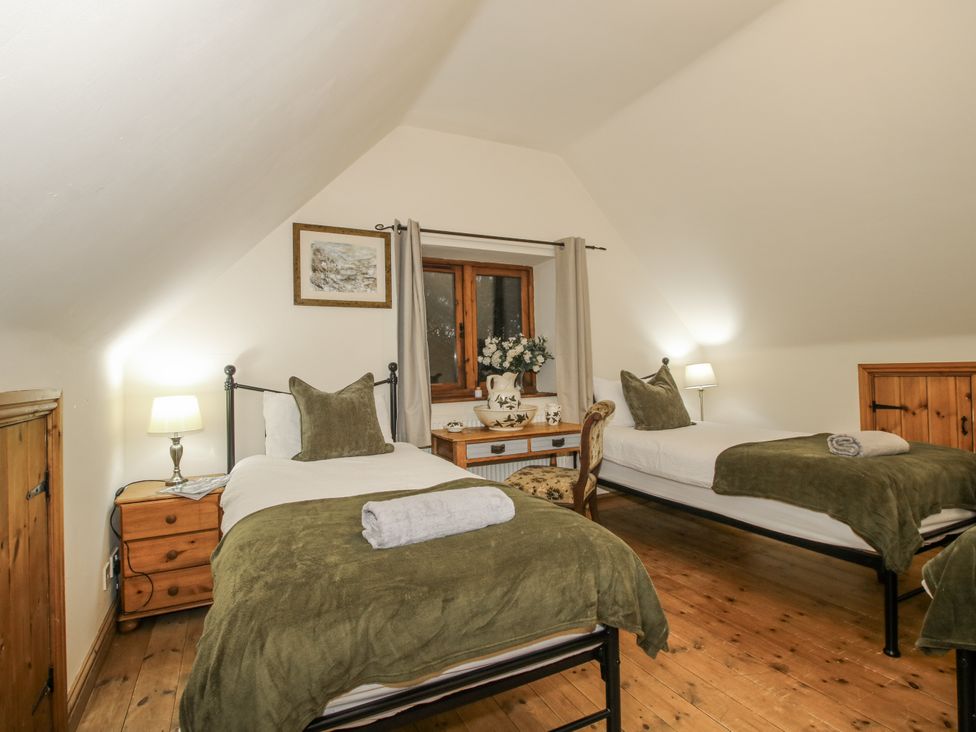 A bedroom with two beds and a table at Upper Home Farm near Cardington