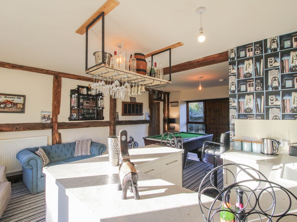 A living room with a pool table and bar counter at Upper Home Farm near Cardington