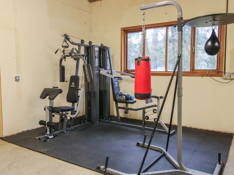 A gym with a weight machine and punching bag at Upper Home Farm near Cardington