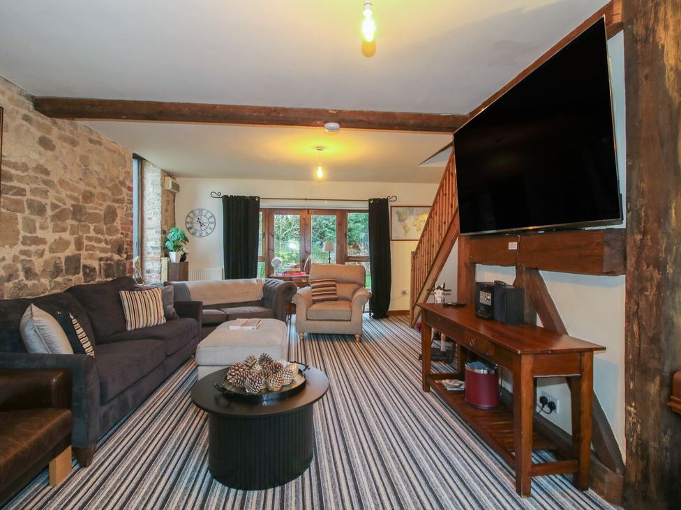 A living room with a television and sofa at Upper Home Farm near Cardington