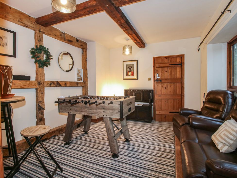 A game room with a foosball table and a recliner sofa at Upper Home Farm near Cardington