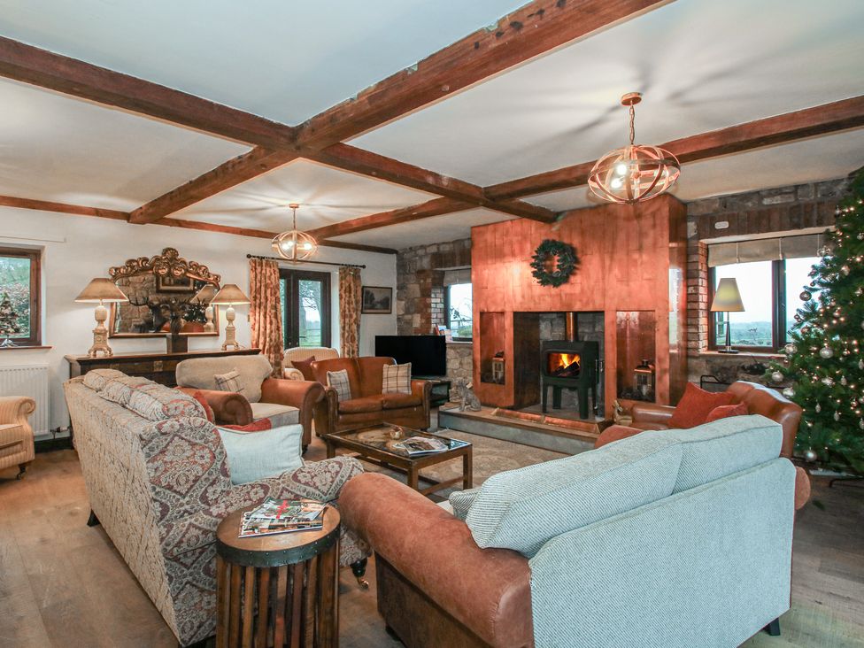 A living room with a fireplace and Christmas tree at Upper Home Farm near Cardington