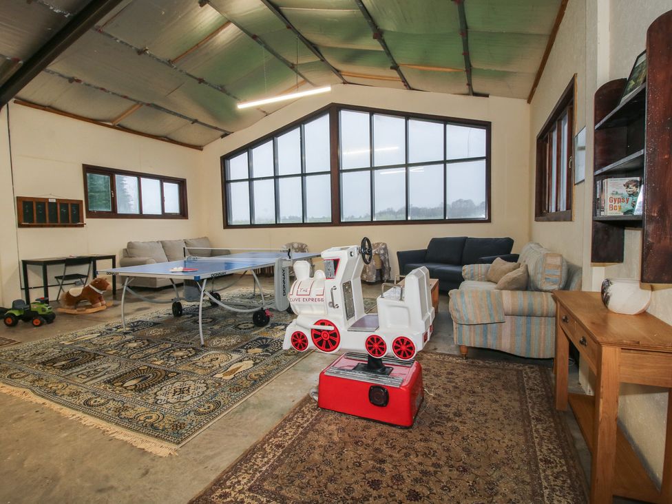 A recreation room with a ping pong table and seating at Upper Home Farm near Cardington