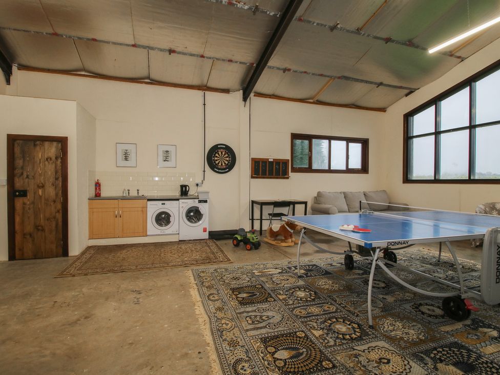A game room with a table tennis table and washing machine at Upper Home Farm near Cardington
