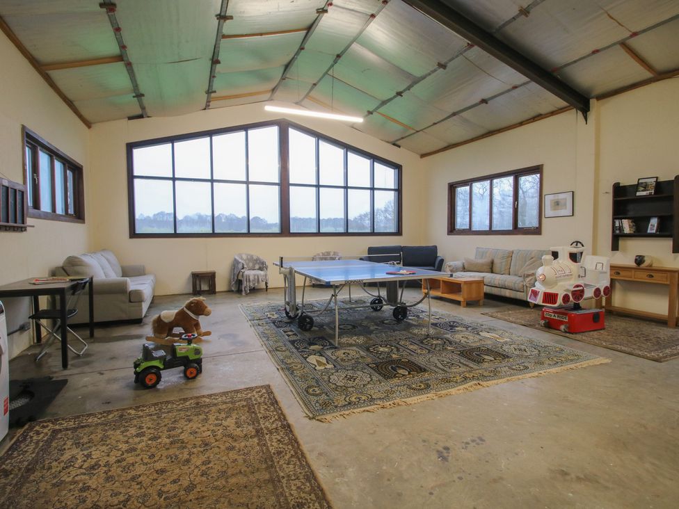 A game room with a table tennis table and sofas at Upper Home Farm near Cardington