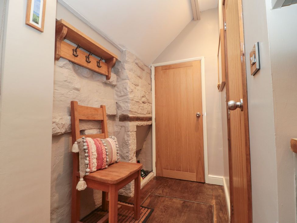 A hallway with a wooden chair and coat hooks at Maltkiln House Annexe in Chop Gate near Stokesley