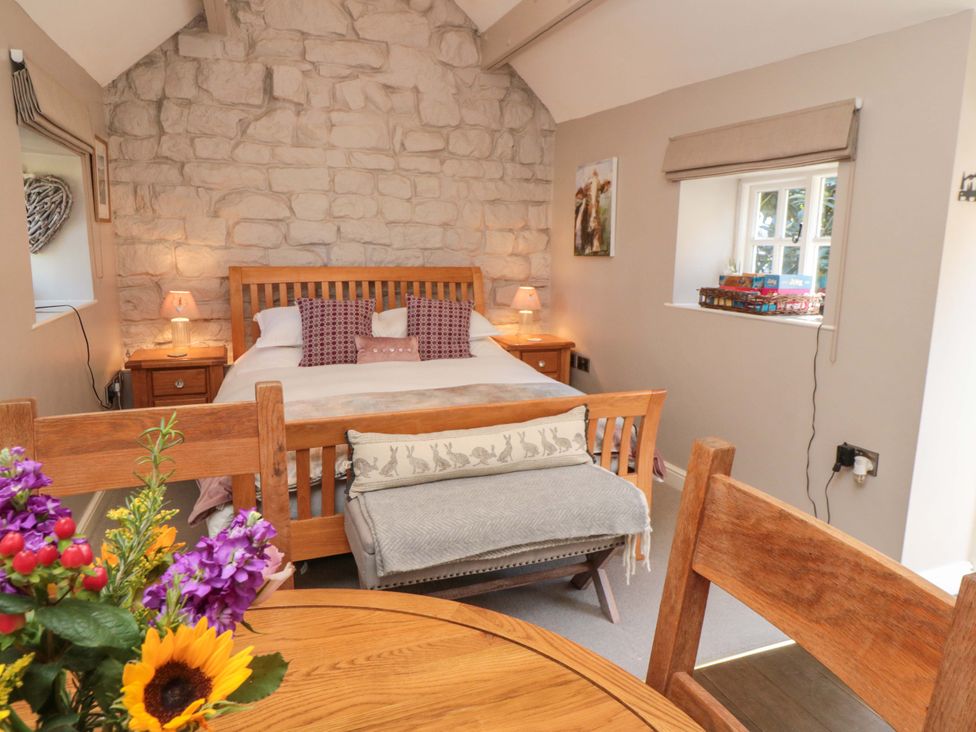 A bedroom with a bed and a table at Maltkiln House Annexe in Chop Gate near Stokesley
