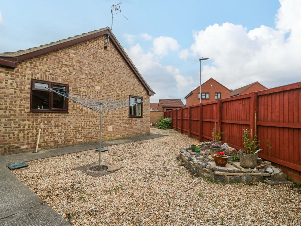 A garden with gravel and flowerpots at Fatima in Burnham-On-Sea