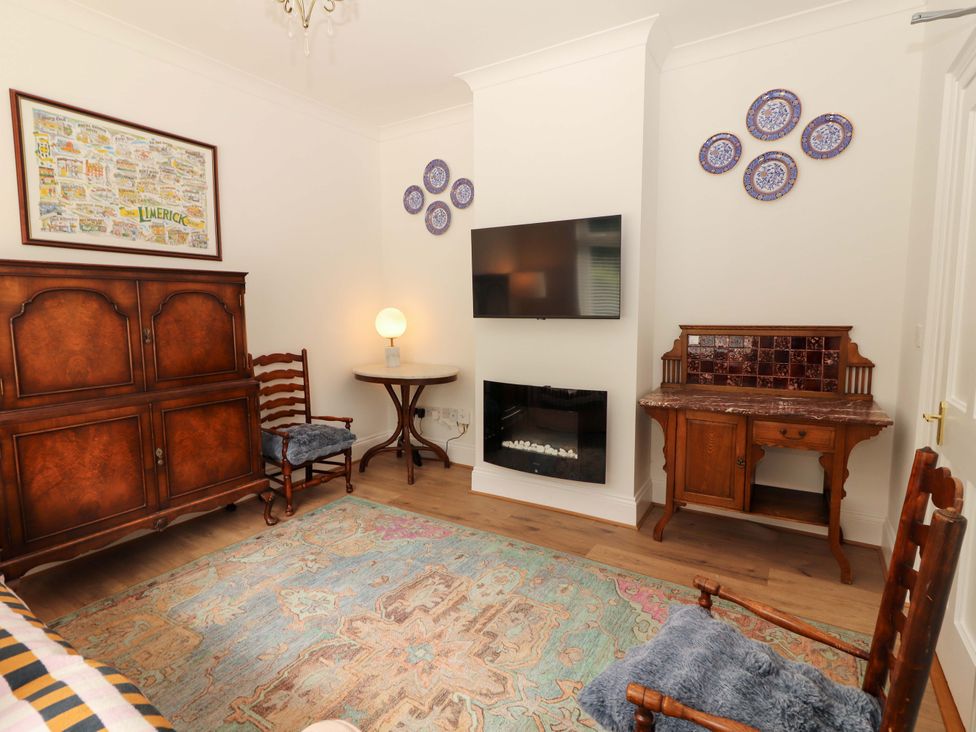 A living room with a television and a chair at Rosemont in Adare