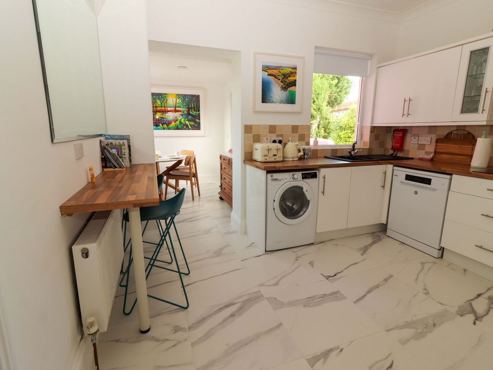 A kitchen with a washing machine and a dining table at Rosemont in Adare
