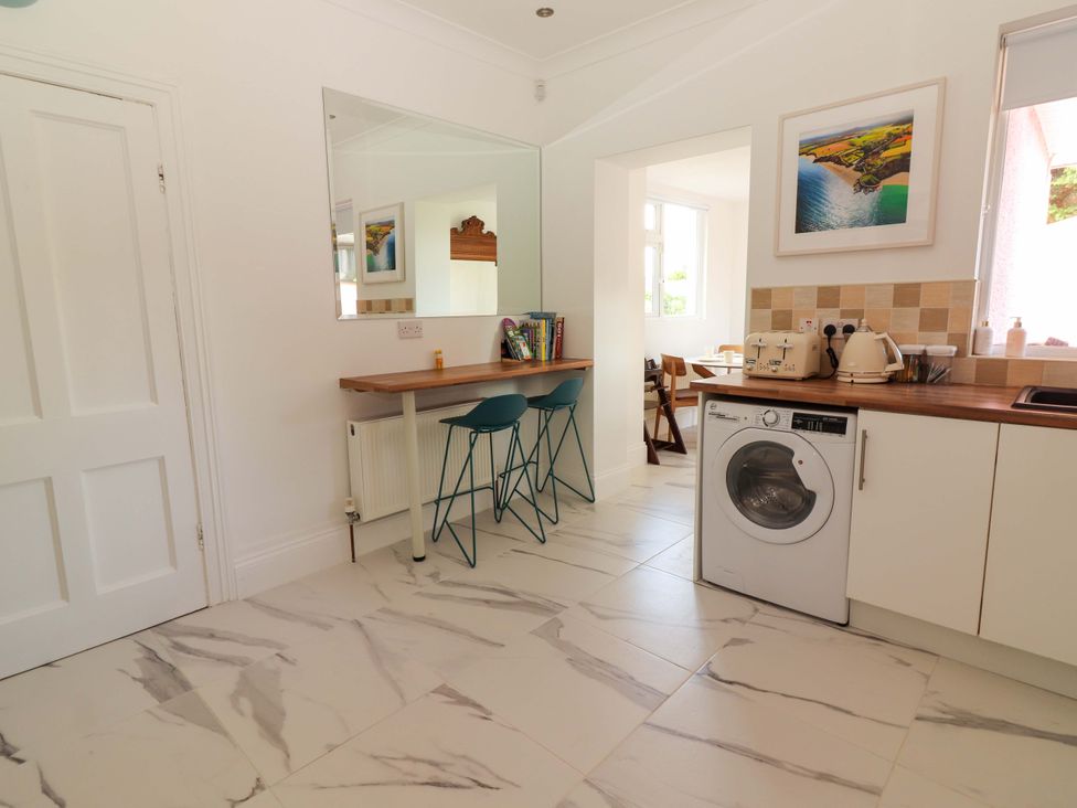 A kitchen with a washing machine and table with chairs at Rosemont in Adare