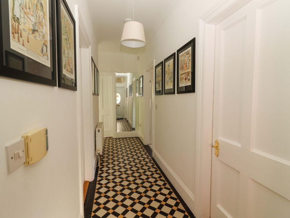 A hallway with framed pictures and patterned floor tiles at Rosemont in Adare