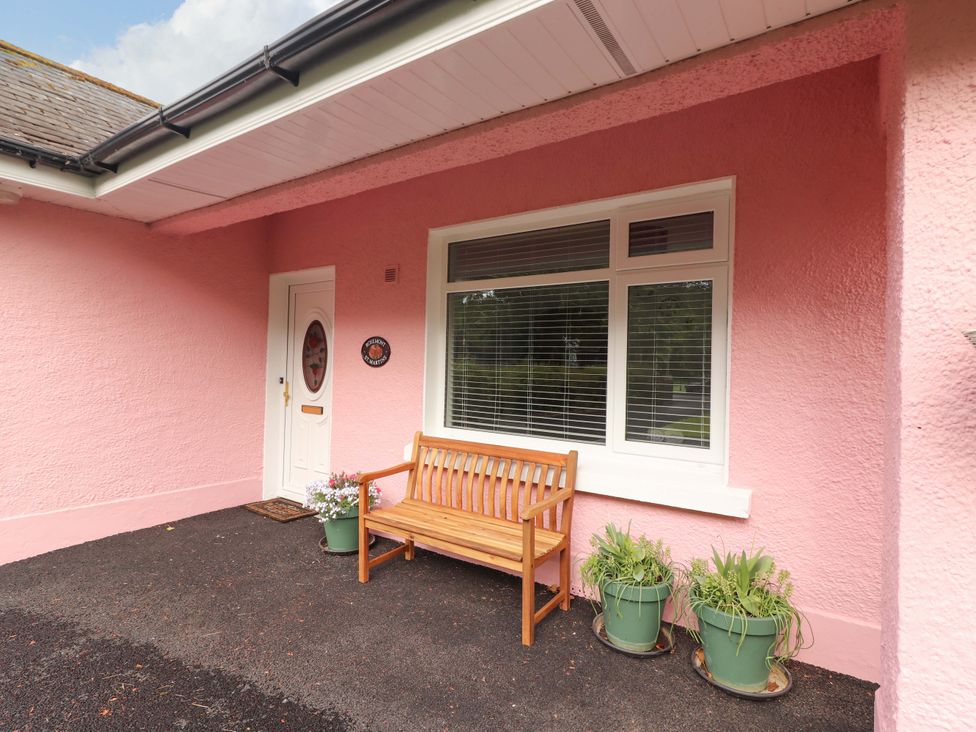 A porch with a bench and planters at Rosemont in Adare