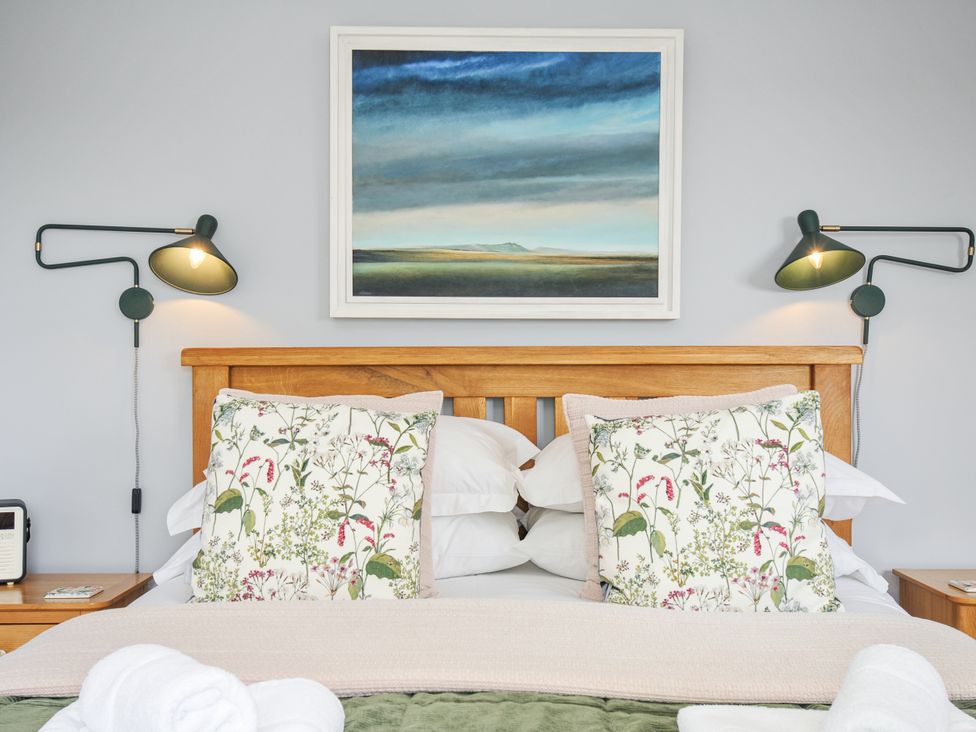 A bedroom with bed and paintings at Smugglers in Bodmin Moor, St Breward near St Tudy
