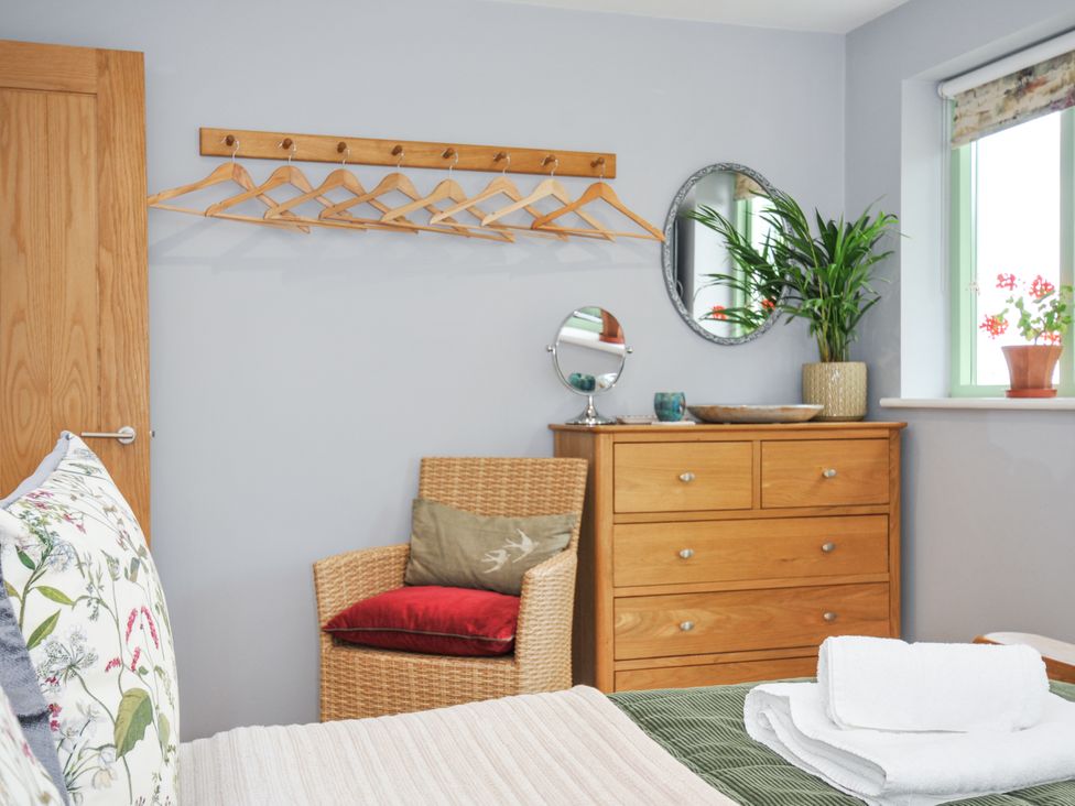 A bedroom with a hanger rack and dresser at Smugglers Bodmin Moor, St Breward near St Tudy