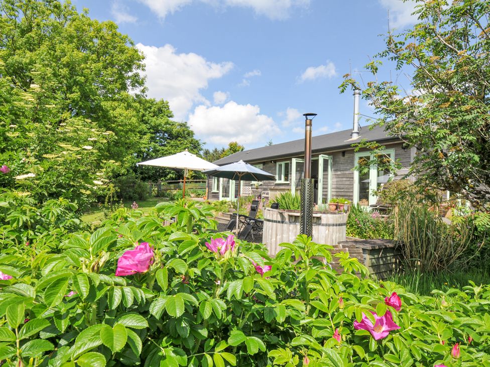 A garden with flowers and a house at Smugglers in Bodmin Moor, St Breward near St Tudy