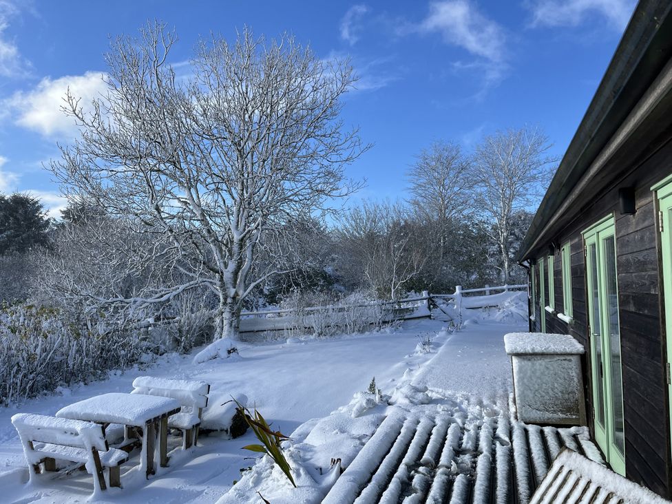 An outdoor area with a table and chairs in snow at Smugglers Bodmin Moor, St Breward near St Tudy
