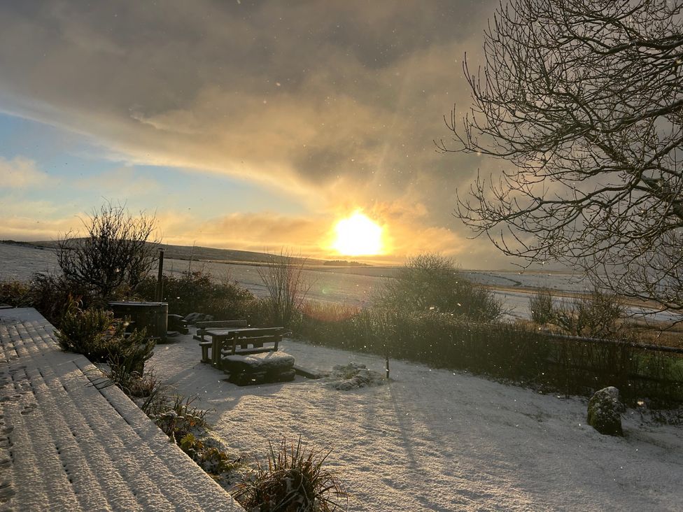 A snowy landscape with a bench and trees at Smugglers Bodmin Moor, St Breward near St Tudy