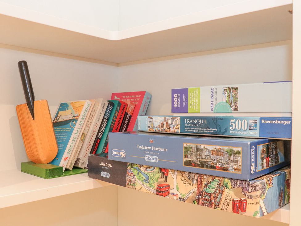 A shelf with books and stacked puzzle boxes at Splatt Barn in Rock
