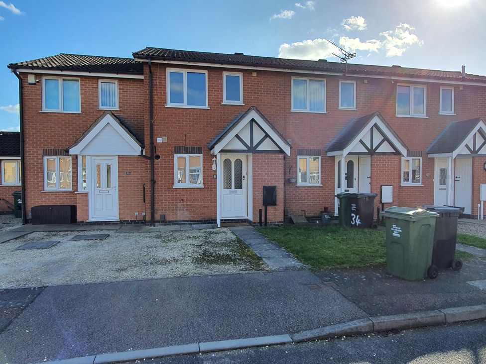 A row of houses with driveways and garbage bins at 32 Moorland House