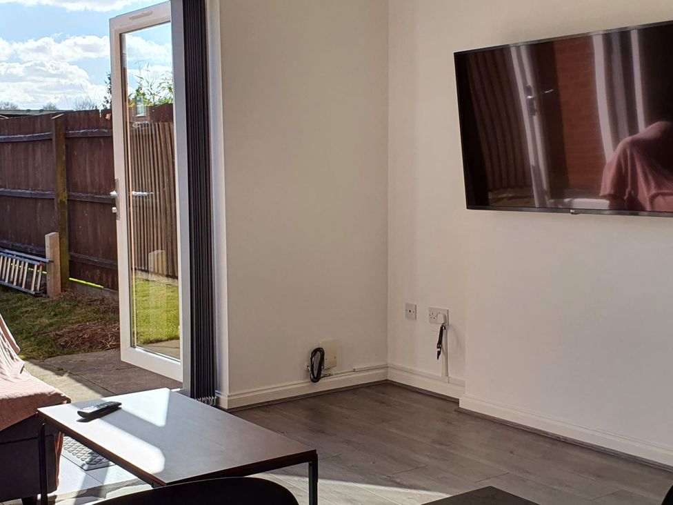 A living room with a TV and a sofa at 32 Moorland House 