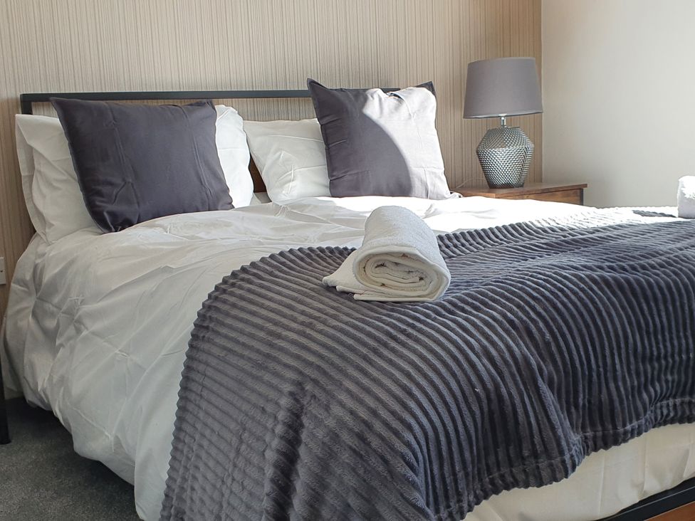 A bedroom with a bed, pillows and a lamp at 32 Moorland House 