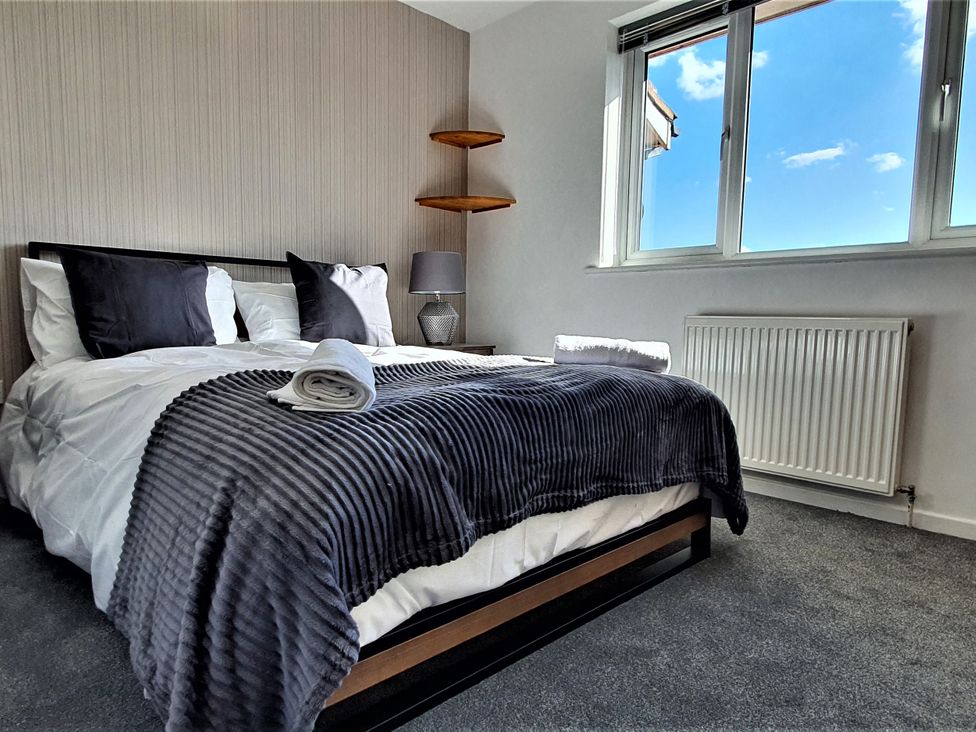 A bedroom with a bed and windows at 32 Moorland House